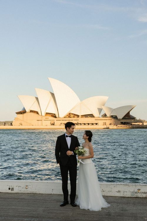 Frank and Seoyun beside Sydney Harbour with the Opera House behind