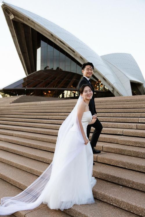 Seoyun's veil trailing down the Opera House steps beside Frank