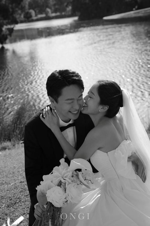 Seoyun laughing against Frank's cheek by the lake, in black and white